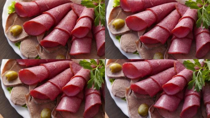 肉类熟食店-火腿，培根，小牛肉舌和jamon在盘子上