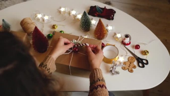 女人的手包装圣诞礼品盒，特写。带有装饰元素和物品的未准备好的礼物圣诞节或新年包装概念。