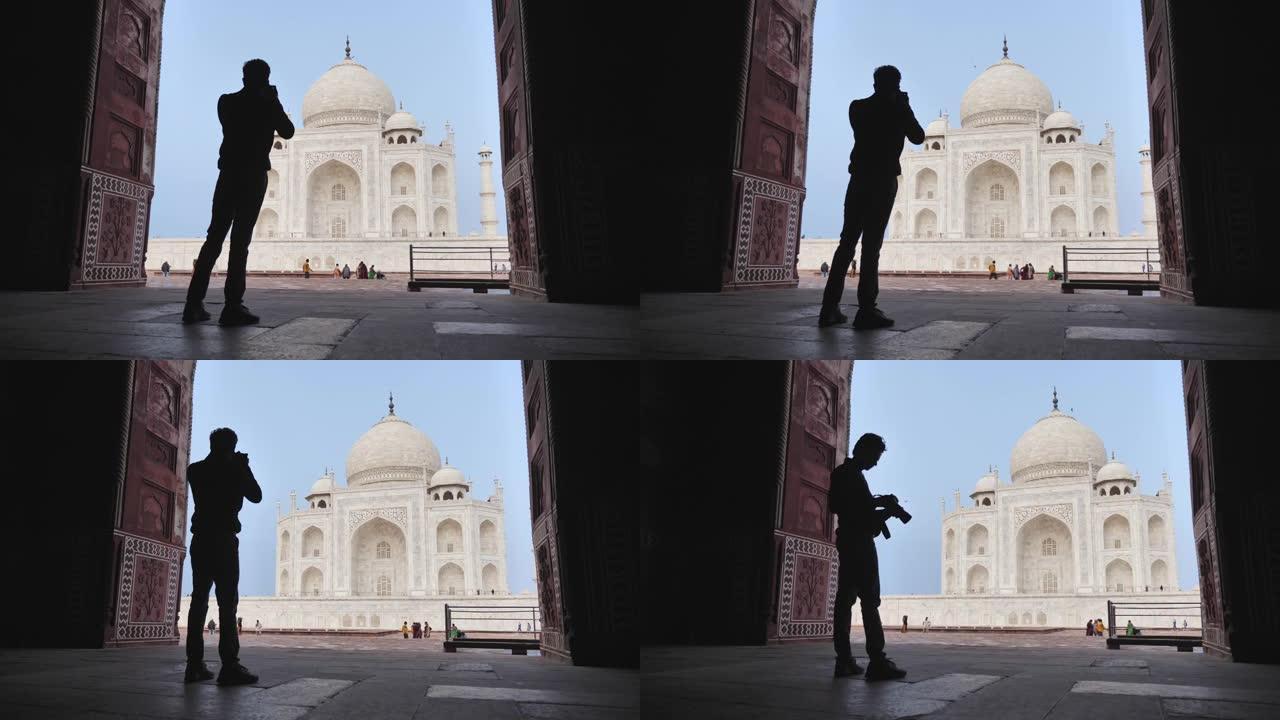 一位年轻的男摄影师拍摄美丽的泰姬陵的剪影