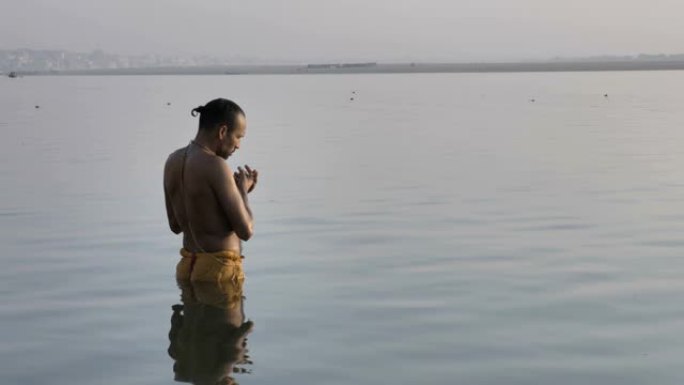 站在恒河岸上的水中的印度教牧师或潘迪特，