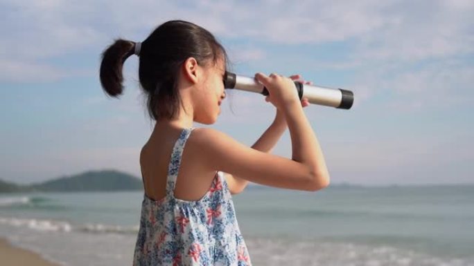 亚洲儿童女孩在望远镜中寻找，快乐的孩子在海滩上户外玩耍