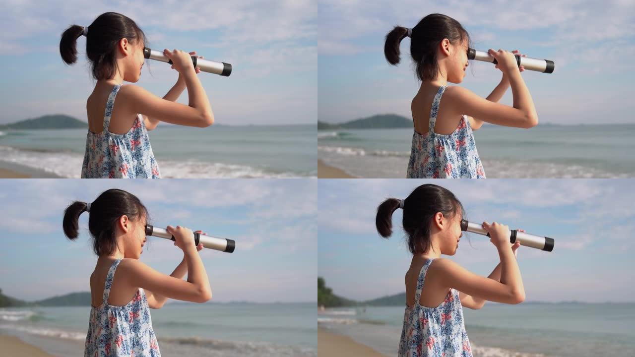 亚洲儿童女孩在望远镜中寻找，快乐的孩子在海滩上户外玩耍