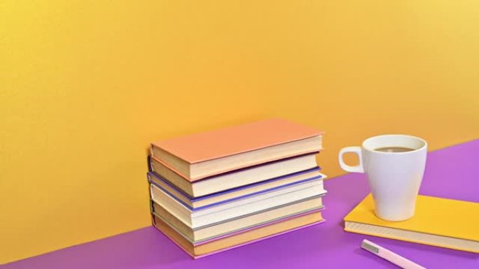 一堆精装复古书籍和一杯带铅笔的咖啡出现在紫色金色主题上。停止运动动画