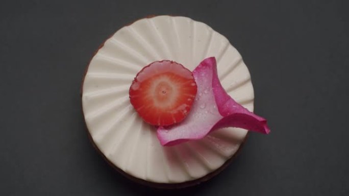 美味甜美的圆形甜点，配白色奶油、草莓和玫瑰花瓣