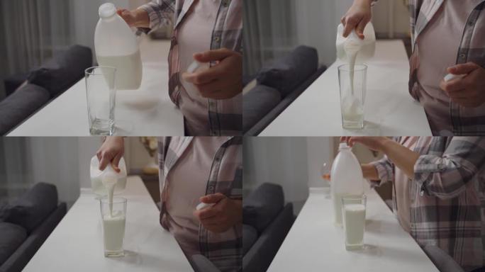 无法识别的女人在室内从塑料瓶中倒出一杯牛奶