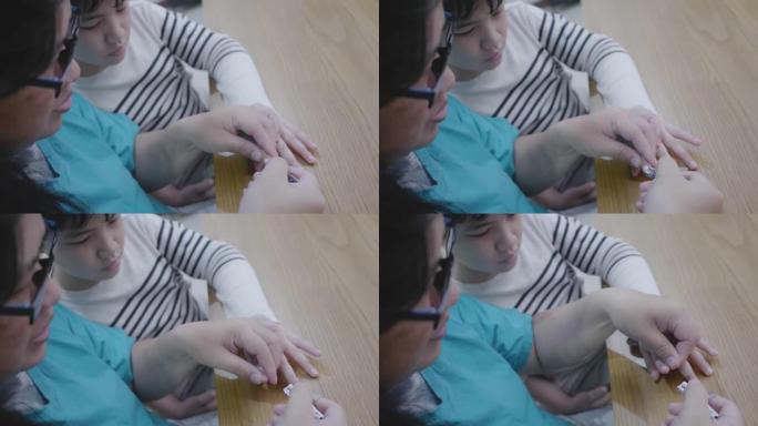 亚洲母亲在屋内割伤儿子的指甲