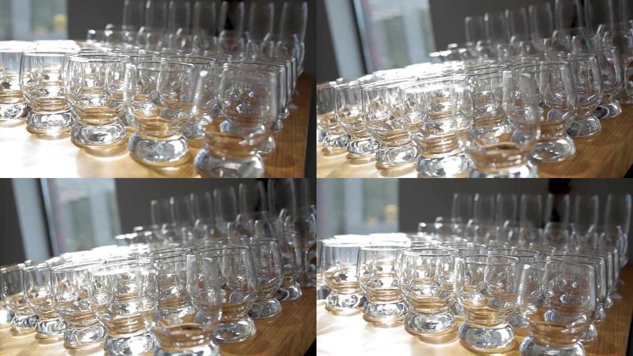 由不同大小的玻璃杯和杯子制成的桌子，用于不同的饮料