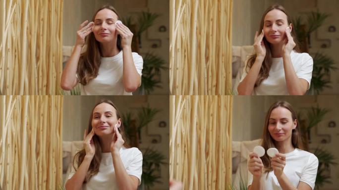 年轻女子在浴室清洁脸部时使用棉垫