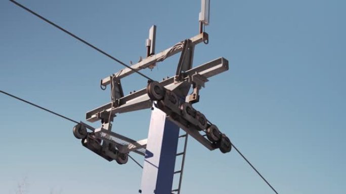 在阳光明媚的冬日，用T型杆拍摄滑雪缆车支撑塔的特写镜头