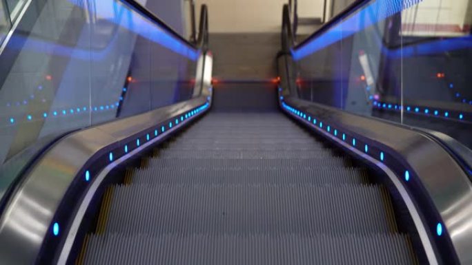 购物中心带照明的工作自动扶梯。自动楼梯在公共场所向下移动