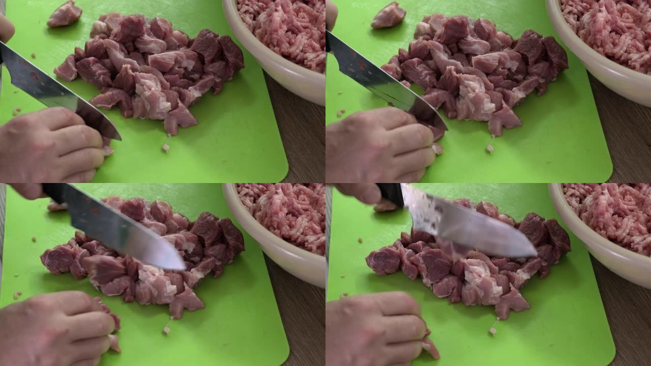 男人的手在厨房特写镜头里用刀切生肉。通过研磨机从新鲜猪肉中制备碎肉。在家做饭，健康饮食和生活方式。选