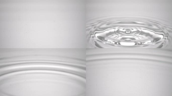 水滴落在灰色流体表面上，形成水环