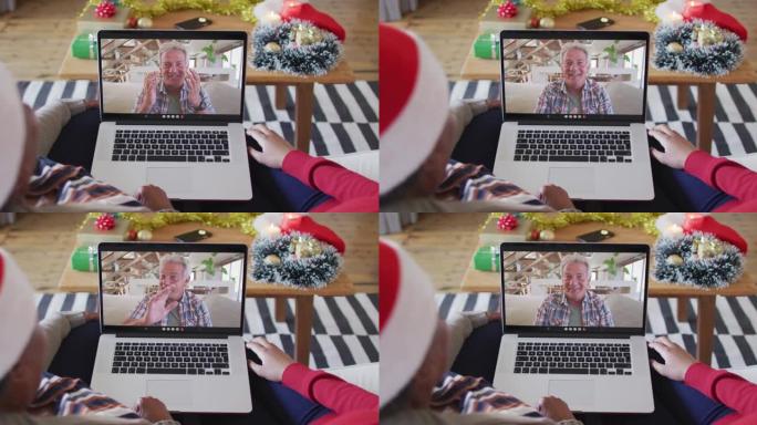 非裔美国母亲和女儿使用笔记本电脑与屏幕上的男人进行圣诞节视频通话