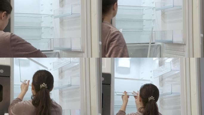全新现代白色厨房，女性清洁内置厨房外壳的空集成冰箱。