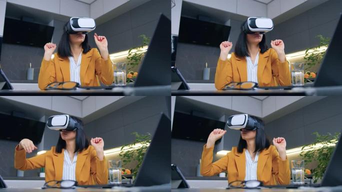 可爱的自信的高超进取的成年黑发女人，穿着橙色夹克，坐在厨房的桌子上，用特殊的3d眼镜，慢动作工作