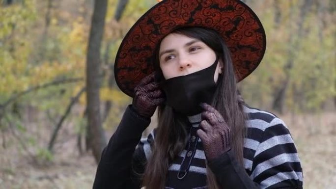 一个穿着巫婆服装的女人在树林里戴着防护医用口罩
