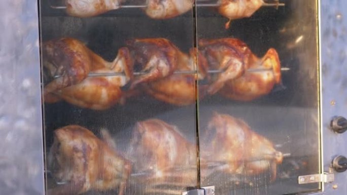 烤鸡在户外封闭的烤箱中在烧烤架上旋转