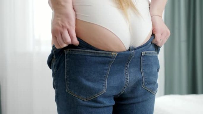 年轻女子，大屁股，宽臀部，穿着紧身牛仔裤。超重、肥胖女性、节食和超重问题的概念