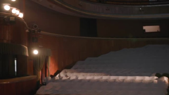 空的经典剧院，有聚光灯，窗帘在剧院或歌剧内一排排空白座位的视野中打开，大厅里没有人，因为大流行