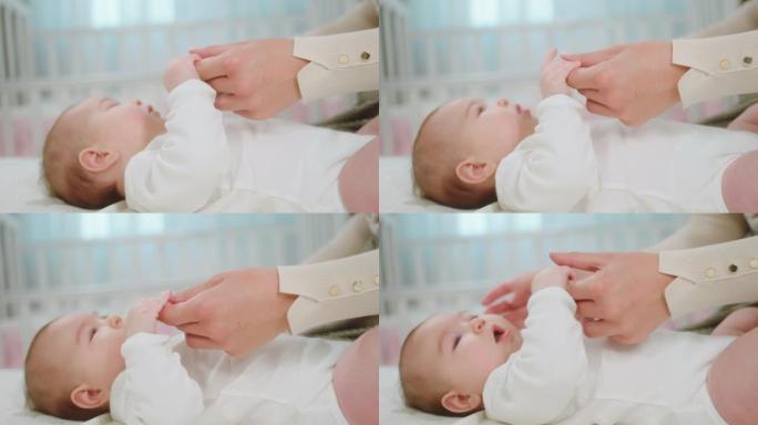 在镜头前，漂亮宝贝与母亲在一起时感到幸福，同时手牵着手，躺在床上