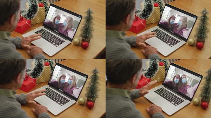 圣诞节时，快乐的高加索高级男子与戴着口罩的女性朋友进行视频通话