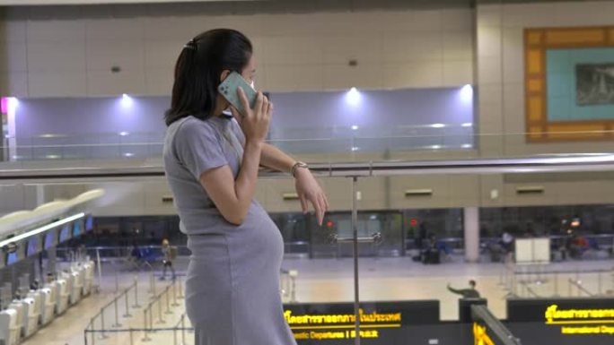 快乐孕妇在机场用手机