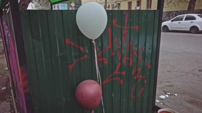 抑郁，庆祝结束了。红色和白色气球设置在贫民窟的垃圾箱附近