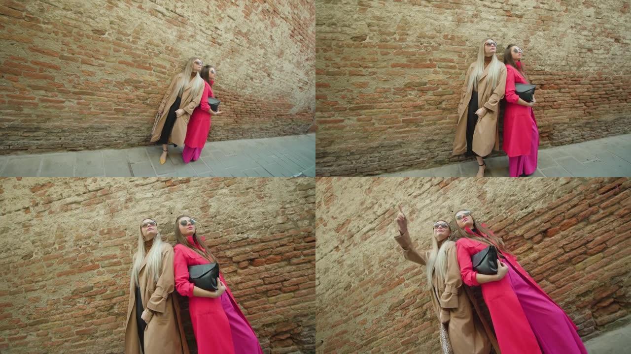 年轻妇女拿着钱包站在威尼斯破旧的墙壁附近