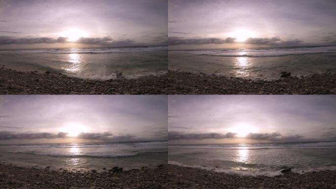 在平静宁静的日落日，金属深绿色蓝色透明泻湖与珊瑚岩石海滩的手持静止视图俯瞰附近的海洋海浪喷雾旋转漂移