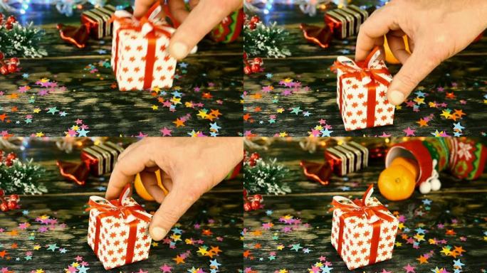 在圣诞节或新年时，将红色蝴蝶结的礼品盒放在桌子上，上面装饰有圣诞节用品，在bokeh garland