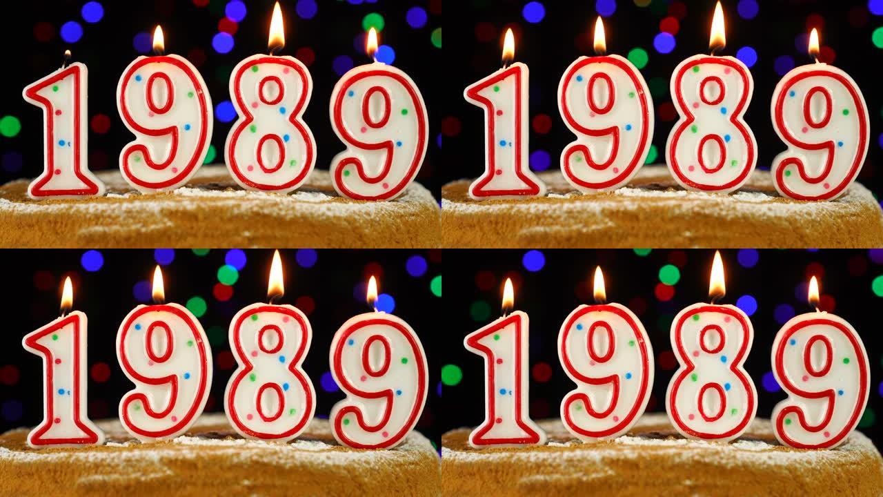 生日蛋糕与白色燃烧的蜡烛在数字1989的形式