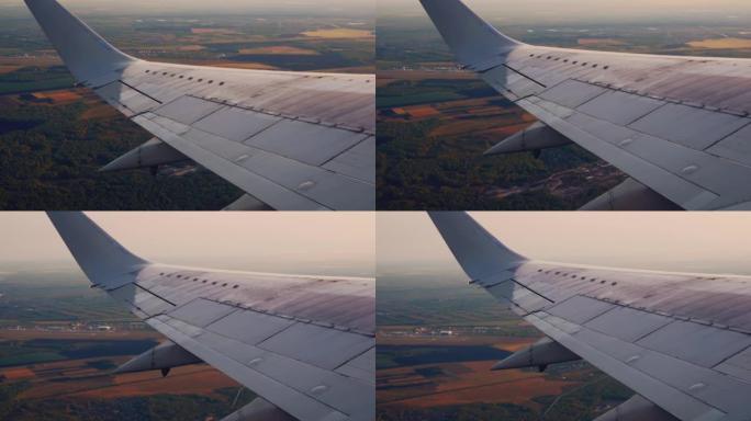 起飞期间飞机机翼的视图，在机场掉头。飞机机翼下低空的建筑物。乘飞机去度假或商务会议