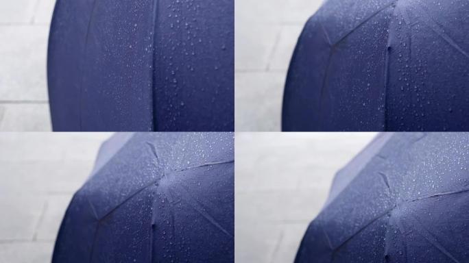 雨天用水滴收上雨伞。从下到上倾斜镜头。主题在右边。