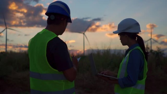 两名亚洲工程师检查工程师在泰国风电场中准备和进度检查具有安全性的风力涡轮机。