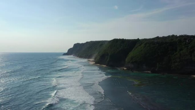 阳光明媚的夜晚巴厘岛著名的melasti海滩湾航空全景4k印度尼西亚