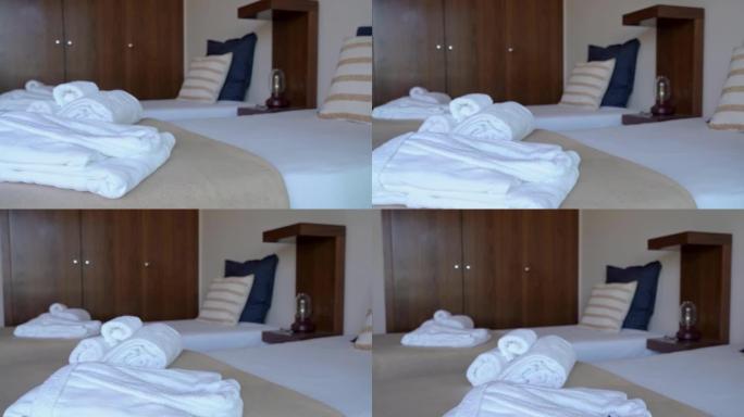 酒店带床和枕头的现代卧室房间的视频拍摄。还有白色毛巾和长袍给招待所游客。
