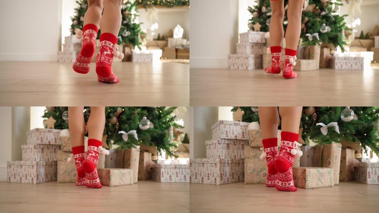 穿着红色新年袜子的女性腿奔向装饰圣诞树的礼物