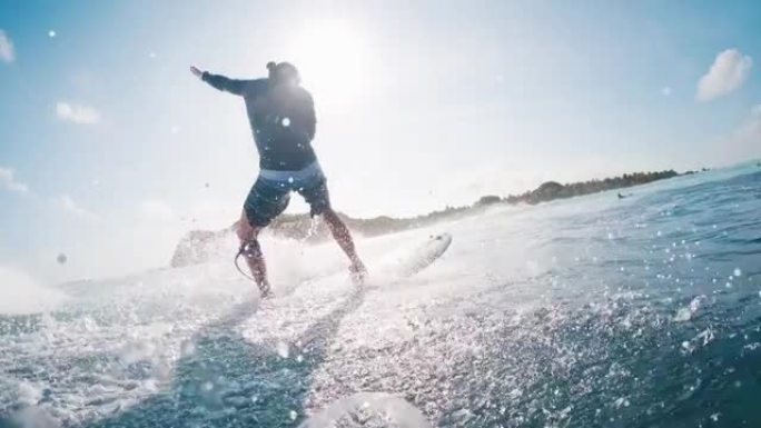 男性冲浪者乘风而入。男子在马尔代夫阳光明媚的日子里冲浪完美的蓝浪