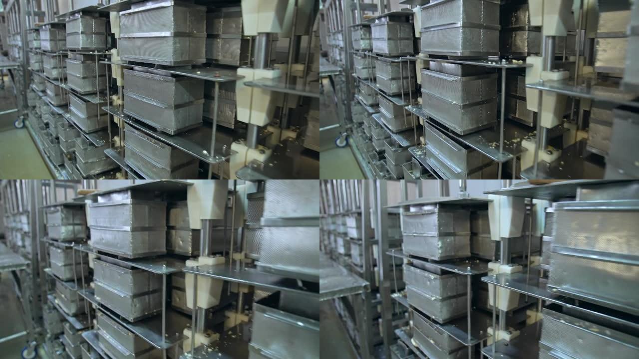 许多不锈钢黄油容器。存放在高大金属架子上的钢制网状黄油盒。现代乳品企业。