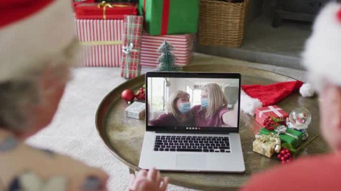 高加索高级夫妇使用笔记本电脑与家人在屏幕上进行圣诞节视频通话