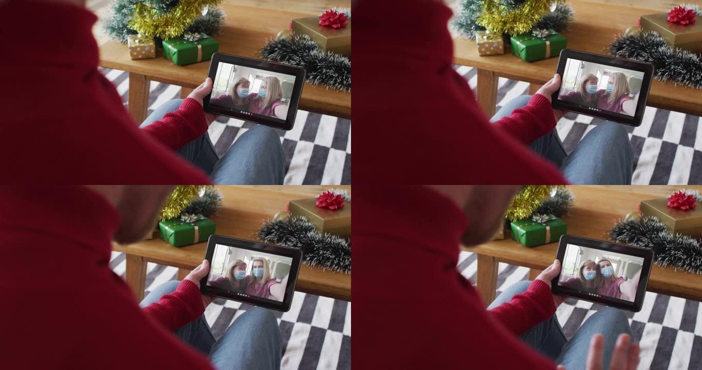 白人男子挥舞并使用平板电脑与屏幕上微笑的家人进行圣诞节视频通话