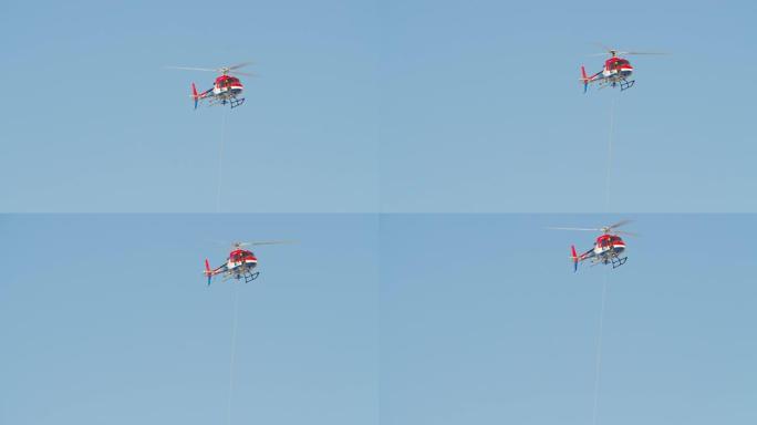 带安全绳的救援游骑兵直升机在阳光下的蓝天中高高飞行