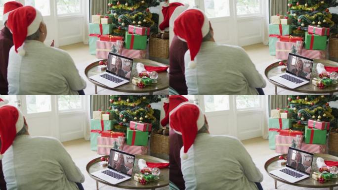 多元化的资深女性朋友使用笔记本电脑进行圣诞节视频通话，屏幕上有接吻的女人