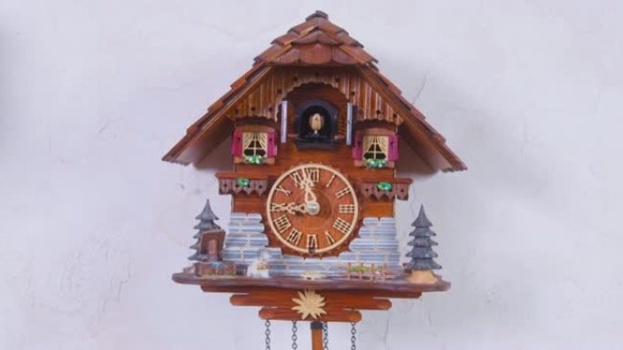 男人在家里的房间里设置了木制的房子形状的挂钟，摆锤悬挂在空的白色墙壁上。
