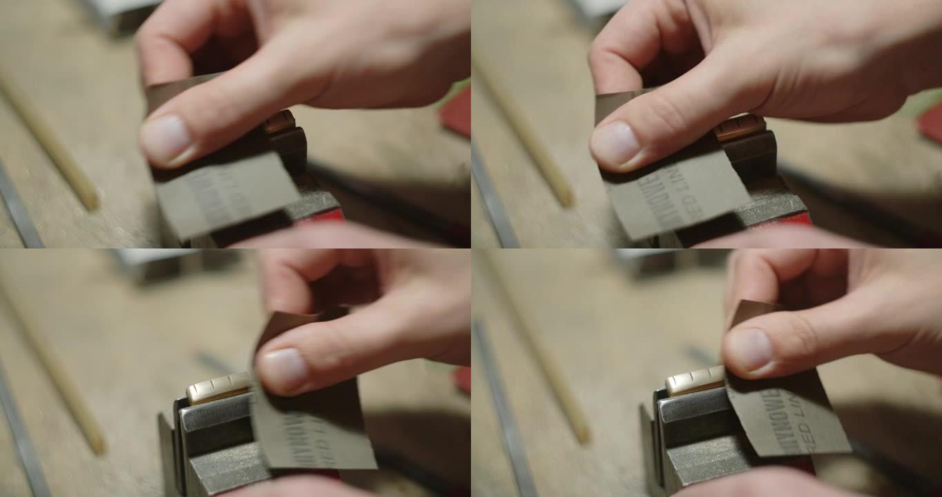 吉他工匠金沙黄铜吉他螺母由砂纸制成。在车间制作乐器和零件，4k 60p Prores