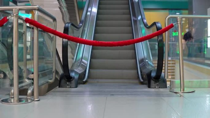 购物中心用带繁文tape节的围栏自动扶梯。通往自动楼梯的通道被堵塞了。封城