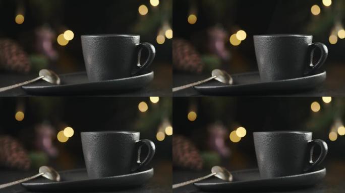 热气腾腾的一杯热咖啡，站在黑暗的桌子上，选择性聚焦。4k运动。舒适的节日圣诞气氛，配有温暖的饮料。桌