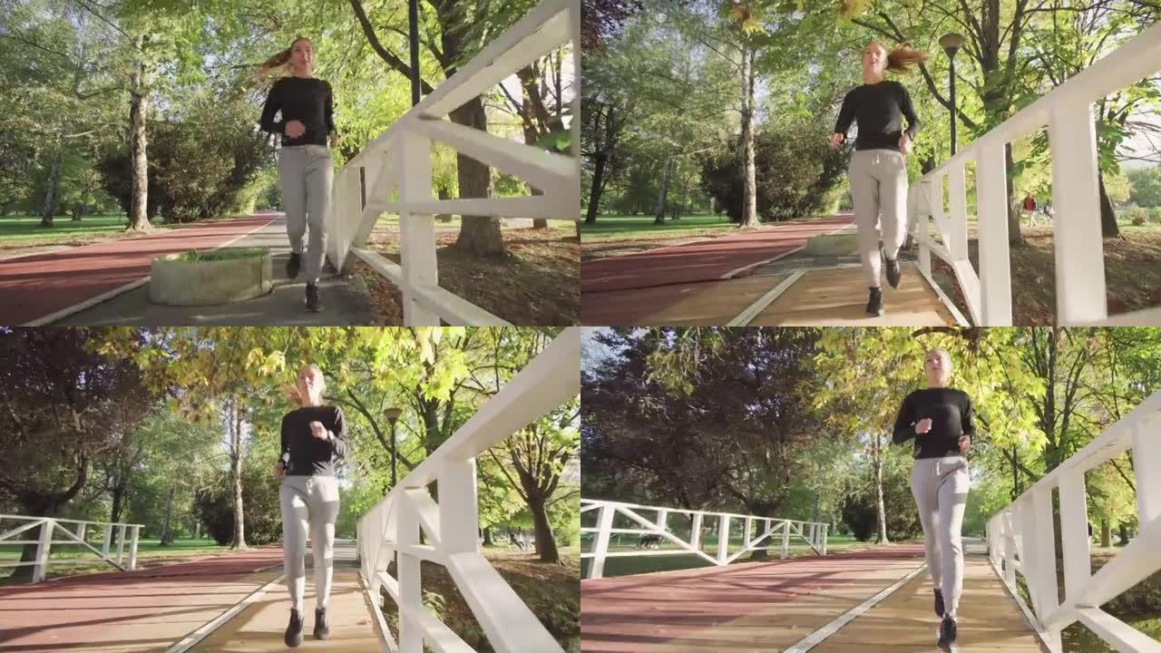 健身女孩在公园木桥上的全天候合成跑道上奔跑。全身射击