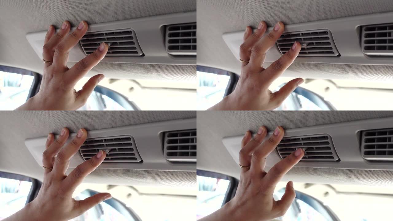 女人把手放在汽车空调格栅窗格上，