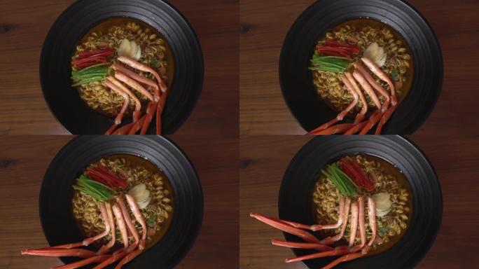 用红蟹煮的辣拉面。黑色碗里旋转的红蟹拉面。